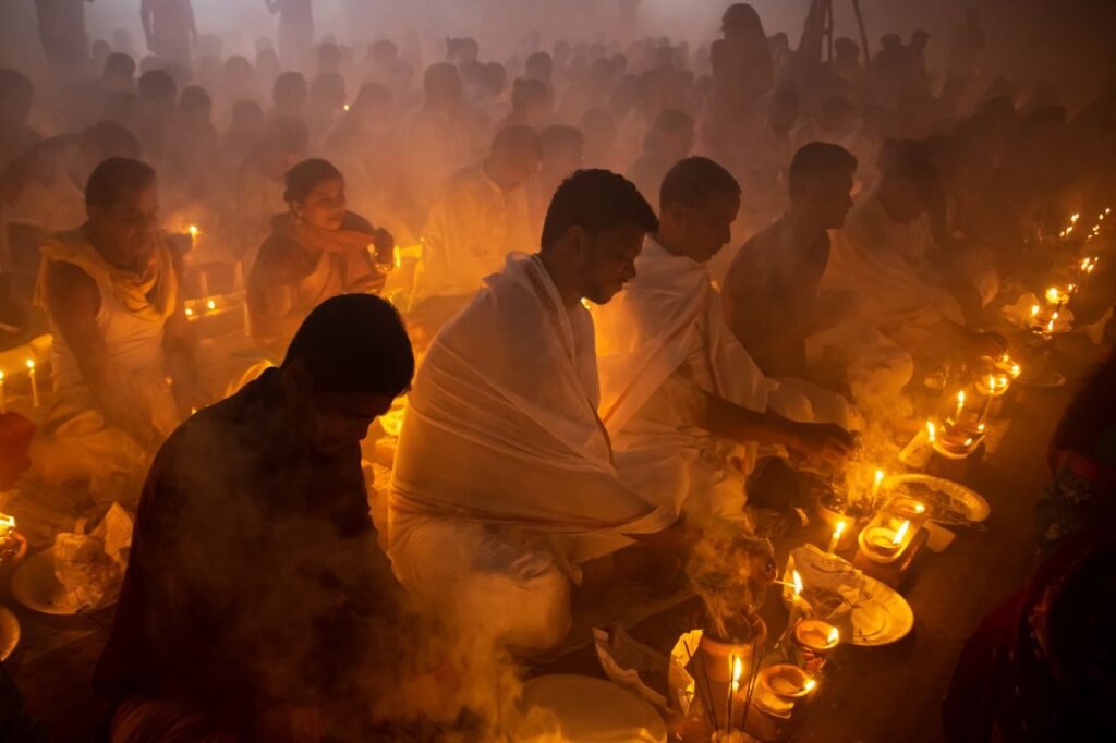People gathered in a dim, smoky room for a spiritual candlelit ceremony, evoking a serene and contemplative mood.